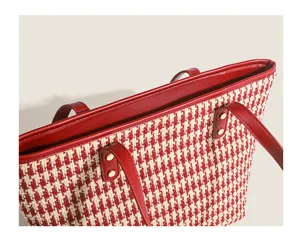 Red and white houndstooth tote bag detail shot with red leather trim and shoulder straps.