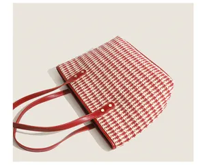 Close-up detail of the red white houndstooth tote bag, showing premium texture and leather handles.