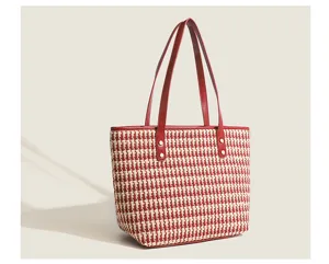 Detailed view of the elegant red and white houndstooth fabric and leather shoulder strap.