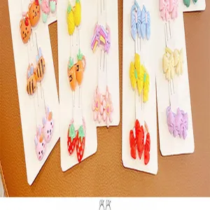 Vista dettagliata di elastici per capelli da bambini, con fiocchi colorati e motivi di frutta.