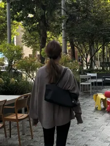 Outdoor street style scene showcasing the casual black minimalist shoulder tote bag in daily use.