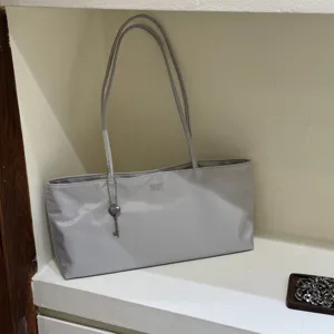 Gray minimalist shoulder tote bag for women, lightweight casual handbag with cute key pendant.
