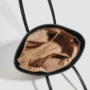 Zwarte lederen tote bag binnenkant uitzicht met klassieke gestreepte voering en zakken.