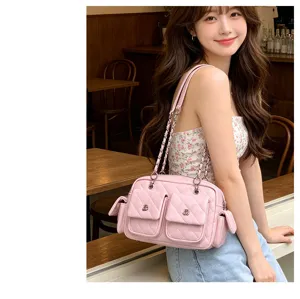Detail shot of a stylish pink quilted shoulder bag with metal chain straps and multi pockets.