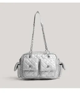 Close-up detail of the silver quilted shoulder bag with chain strap and multi front pockets.