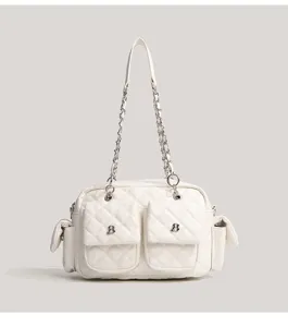 Close-up view of the white quilted shoulder bag featuring silver chains and multi-pockets.