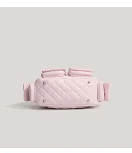 Pink quilted motorcycle bag bottom detail with metal feet and multiple side pockets.