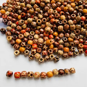 Detailed view of colorful wooden beads with vintage patterns, perfect for hair braids and DIY crafts.