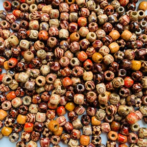 Detailed view of colorful printed wooden beads, ideal for DIY jewelry and dreadlock hair.