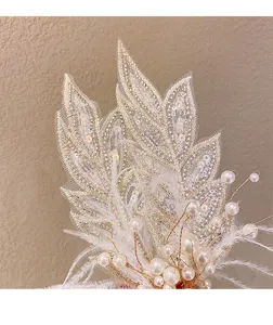 Accessoire de cheveux élégant en perles, plumes et feuilles pour mariage et spectacle.