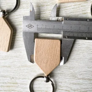 Beech wood keychain detail view, solid wooden house pendant measurement display closeup.