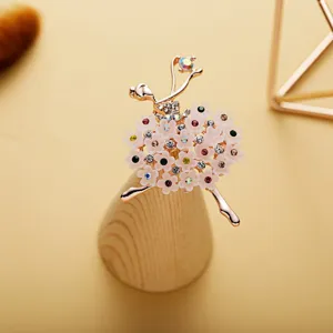 Close up detail shot of a delicate ballerina brooch featuring sparkling rhinestones and floral skirt.