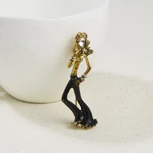 Elegant dancing girl brooch detail, gold-tone metal with black enamel and sparkling rhinestones.