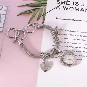 Silver charm bracelet watch for women, fashionable quartz timepiece with rhinestone heart pendant.