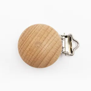 Dettaglio clip ciuccio in legno di faggio, superficie liscia con chiusura in metallo sicura.