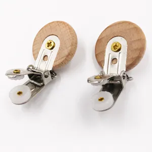 Dettaglio clip ciuccio in legno con disco di faggio, pinza metallica e ingranaggio in plastica pura.