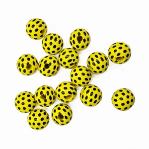 Close-up of 16mm yellow wooden beads with black polka dots, ideal for DIY crafts and jewelry.