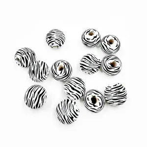 Close-up detail of 16mm black and white zebra pattern wooden beads for DIY crafts and jewelry making.