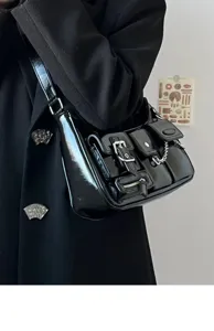 Detailed shot of a black patent leather Y2K shoulder bag with multi pockets and chain strap.