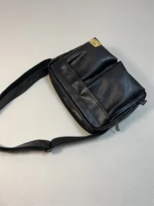 Black PU leather messenger bag detail, casual crossbody design with multiple pockets.