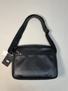 Black leather messenger shoulder bag detail, casual daily crossbody bag with zipper pocket.