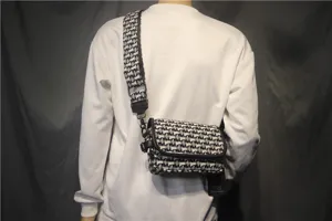 Vue rapprochée détaillée du sac bandoulière en toile noir et blanc avec sangle.