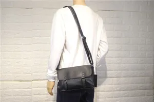 Black leather vintage style messenger bag with flap and double buckles worn by model