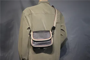 Details view of men casual crossbody shoulder bag with striped webbing strap and flap design.