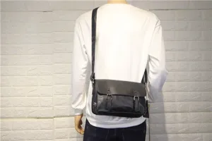 Details of the men's black vintage leather messenger bag showing buckle and strap.