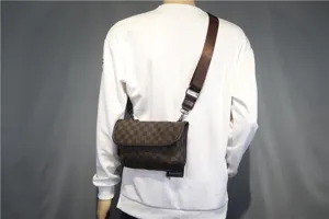 Sac bandoulière marron à motif damier pour hommes avec sangle réglable et fermeture à rabat.