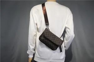 Vue détaillée du sac bandoulière marron à motif damier avec rabat et sangle large pour homme.
