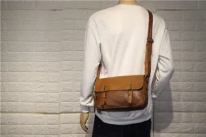 Vintage brown leather messenger bag worn by model, showing casual daily style detail.