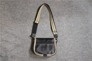 Black leather crossbody bag with striped webbing strap, casual shoulder bag detail view.