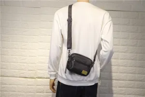 Sac bandoulière homme en cuir noir petit sac de transport quotidien avec sangle réglable chic.