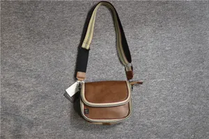 Casual brown leather crossbody bag with stylish striped shoulder strap, compact design.