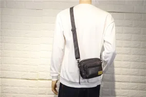 Sac bandoulière décontracté pour homme en cuir foncé, petit sac messager pour voyage quotidien.