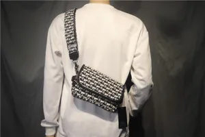 Sac bandoulière en toile noir et blanc avec sangle large pour le style quotidien et loisir.