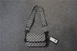 Sac bandoulière en toile géométrique noir et blanc avec large sangle pour hommes et femmes.