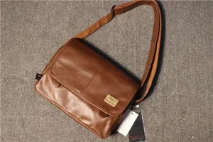Détail de sac bandoulière en cuir marron montrant le rabat et la sangle réglable.