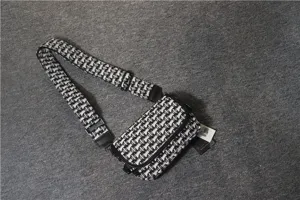 Vue détaillée du sac à bandoulière élégant en toile noire et blanche avec sangle réglable.