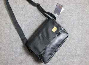 Detail view of black leather mens messenger bag, vintage crossbody style with adjustable strap.