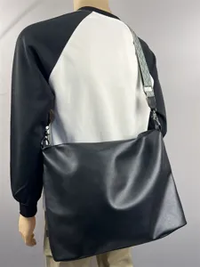 Detailed view of the black men's crossbody messenger bag with wide geometric strap.