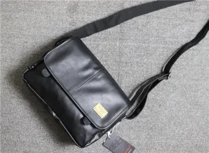 Detail view of men's black PU leather messenger bag, vintage shoulder bag close-up.