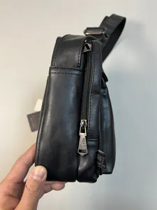 Black PU leather messenger bag side detail view, casual crossbody bag zipper closeup.
