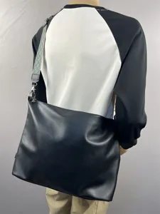 Men large capacity black leather messenger bag with stylish woven shoulder strap detail view.