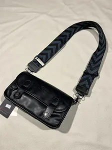 Black vintage messenger bag for daily use with wide chevron shoulder strap and metal hardware.