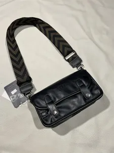 Black vintage shoulder bag detail, wide chevron strap, premium PU leather and metal hardware.