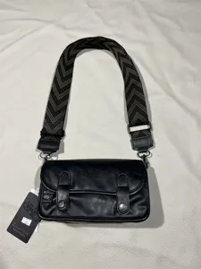 Threebox vintage black crossbody bag with wide patterned strap and flap buckle design.