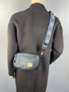 Men's stylish black leather crossbody bag with patterned web strap, casual shoulder bag.
