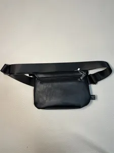 Black PU leather casual waist bag for men, adjustable sling strap, rear zip pocket detail.